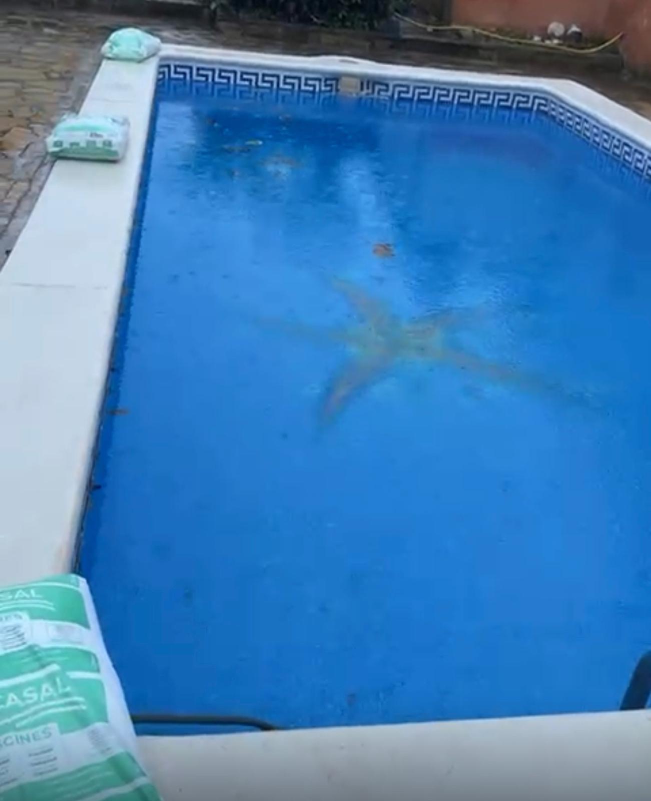 Piscina azul durante el proceso de limpieza y rehabilitación