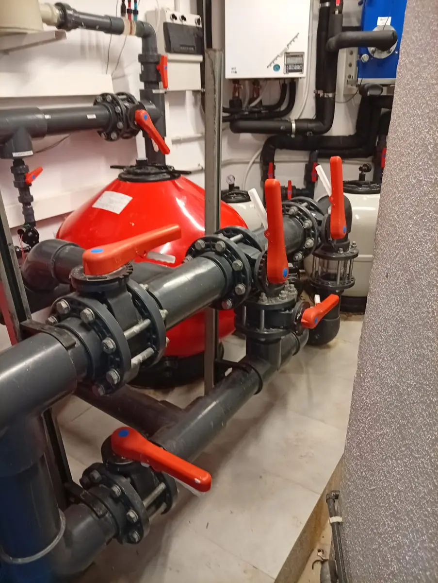 Sala de máquinas de piscina con filtros, tuberías y válvulas