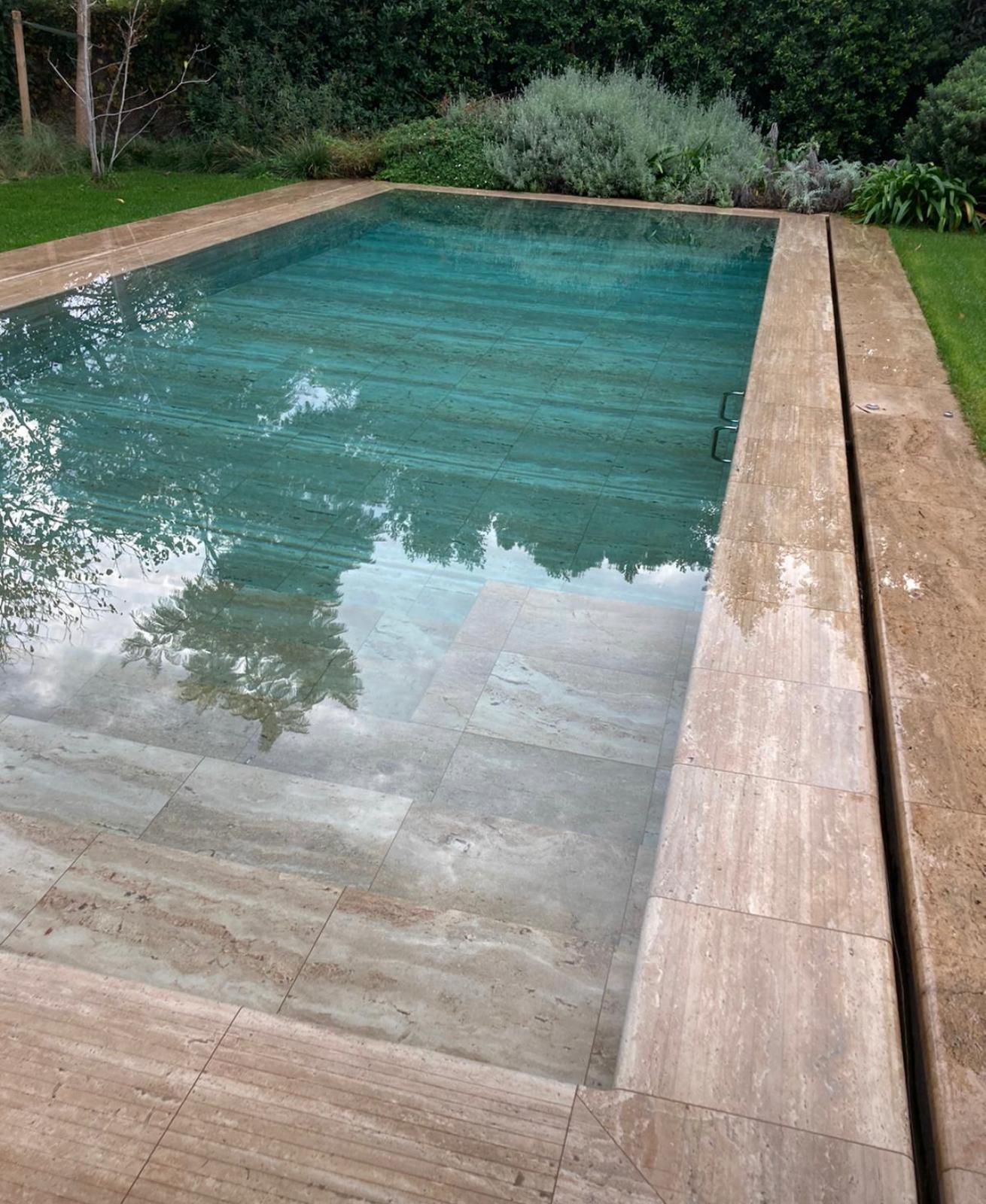 Piscina puesta a punto en verano con agua clara y entorno ajardinado